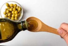 Diabetes Trigger In Everyday Diet Fat? Pouring olive oil from a bottle into a wooden spoon