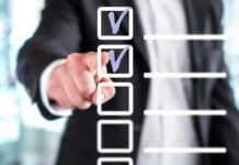 person in suit pointing at a digital checklist