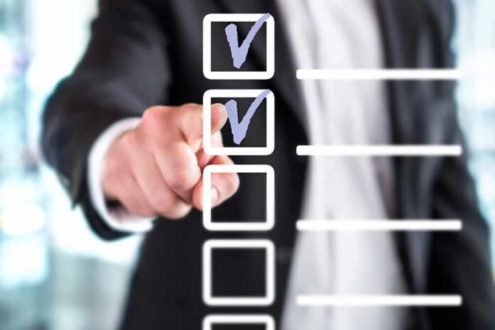 person in suit pointing at a digital checklist