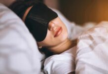 Do You Actually Burn Calories When Sleeping? Woman sleeping with a black eye mask in bed