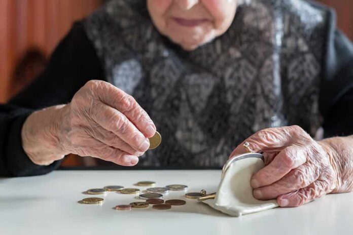 Elderly person counting coins on a table