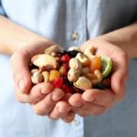 Hands holding mixed nuts and dried fruit