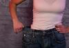 The Cost Of Losing Weight Too Quickly person in white tank top showing loose jeans waistband