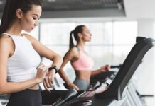 Japan’s Giant Study Upends Sleep Advice Woman on treadmill checking smartwatch in gym