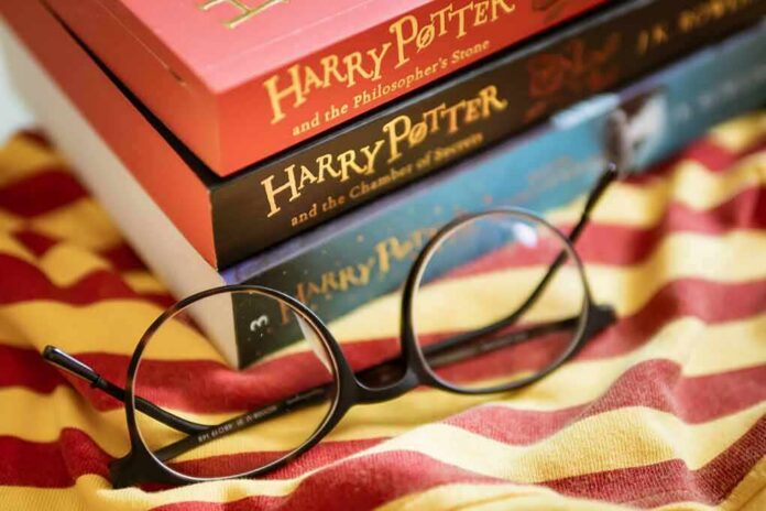 shutterstock_1454161316 Round black glasses on striped scarf beside Harry Potter books
