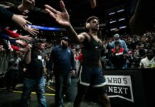 Basketball player in arena high-fives fans while wearing headphones