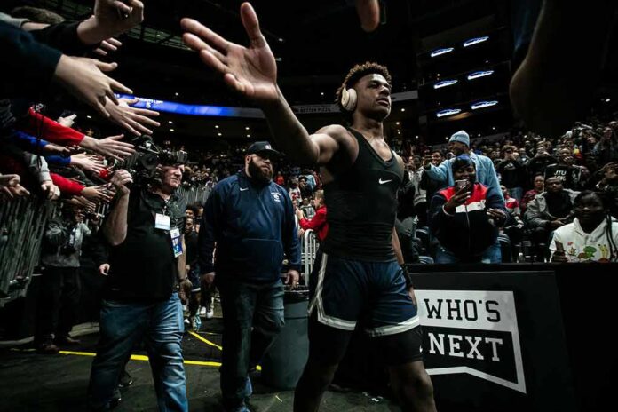 Basketball player in arena high-fives fans while wearing headphones