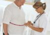 Weight-Loss Showdown: GLP-1 vs. bariatric surgery A healthcare professional measuring a patients waist with a tape measure