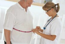 Weight-Loss Showdown: GLP-1 vs. bariatric surgery A healthcare professional measuring a patients waist with a tape measure