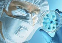 Lab Viruses Cures Cancer Scientist in protective gear examining a petri dish
