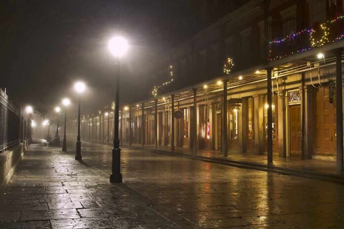 shutterstock_2184519327 Foggy street with lit lampposts and decorated storefronts at night