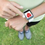 Person checking smartwatch heart rate on wrist outdoors