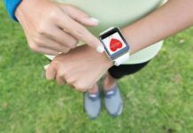 Harvard Wearables Expose Deadly Heat Damage Person checking smartwatch heart rate on wrist outdoors