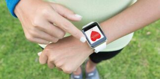 Person checking smartwatch heart rate on wrist outdoors