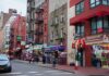 City street with brick buildings, fire escapes, and busy storefronts