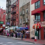City street with brick buildings, fire escapes, and busy storefronts