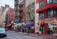 City street with brick buildings, fire escapes, and busy storefronts