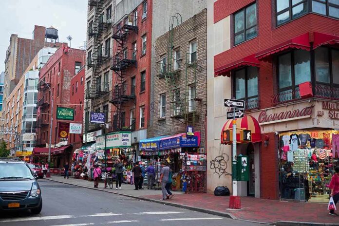 City street with brick buildings, fire escapes, and busy storefronts