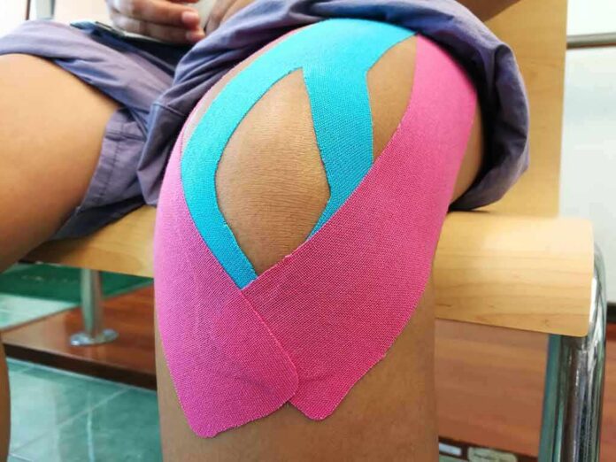 Knee with colorful kinesiology tape applied