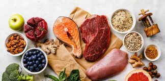 Assorted healthy foods with salmon, beef, chicken, fruits, vegetables, nuts, and grains