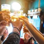 group toasting with beer glasses in a pub