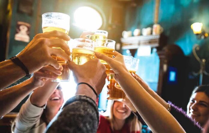 group toasting with beer glasses in a pub