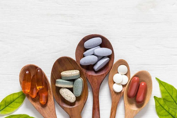 shutterstock_1167230344 Assorted dietary supplements on wooden spoons