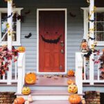front porch decorated for Halloween with pumpkins and bats