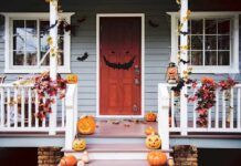 front porch decorated for Halloween with pumpkins and bats