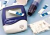 $10 Cambridge Chip Could Read Your Blood Sugar Blood glucose monitor with testing strips and a lancing device on a blue background