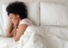 Bedtime Mistake Torches the Spine Woman sleeping on white bedding
