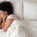 Woman sleeping on white bedding