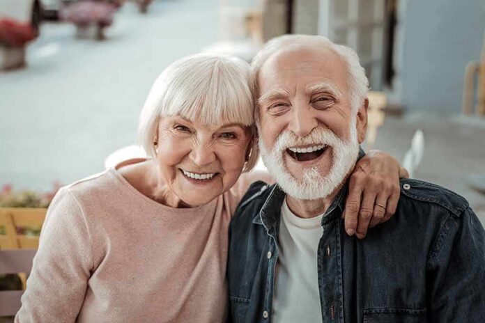 shutterstock_1565185228 Smiling elderly couple embracing outdoors
