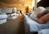 Man resting on a bunk in a shared dormitory room