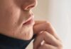 Eczema, Acne or Rosacea Won’t Clear? Might Be Your Gut Close-up of lower face with acne scars and hand pulling up fabric