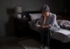 Bedtime Myth Shattered By Top Sleep Docs Older adult sitting on bed with head in hand