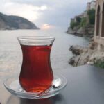 Glass of tea on a saucer by the seaside