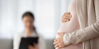 Pregnant woman holding belly during medical visit