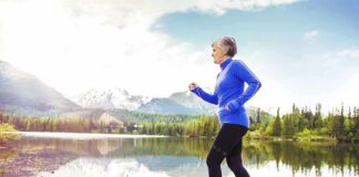 Older woman jogging on a wooden dock by a mountain lake