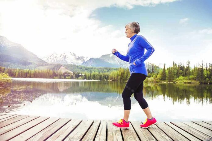 shutterstock_222565726 Older woman jogging on a wooden dock by a mountain lake