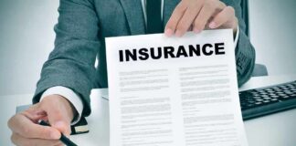 Person in suit holding an insurance document and a pen