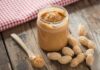 Peanut Butter Twist: Blood Fats Rewired Jar of peanut butter with spoon and peanuts on rustic table