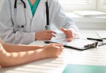 Why Autoimmune Conditions Hit Women Harder Doctor discusses medical notes with patient at a desk
