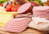 Assorted deli meats and sliced cheese on a wooden board
