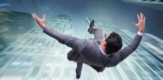 businessman falling between tall skyscrapers
