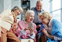 Scientists discover key to staying mentally sharp in old age Group of seniors smiling and looking at a smartphone together