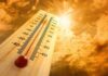 A thermometer displaying temperature against a sunset sky